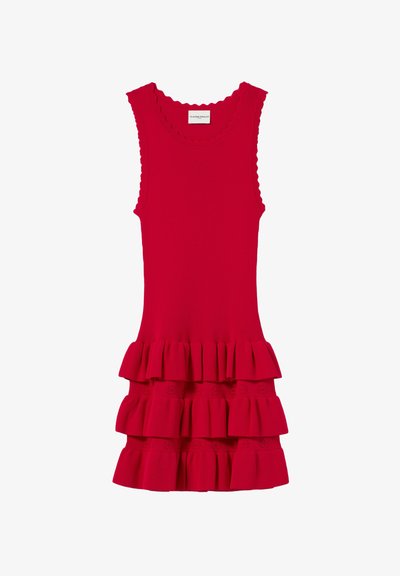 Robe rouge à côtes avec un col festonné et trois volants superposés dotés de détails en œillets en bas. Design sans manches.