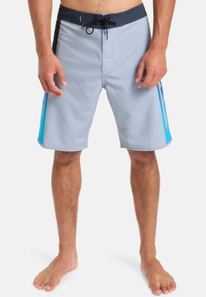 Hellgraue Boardshorts mit einem marineblauen Bund, schwarzen Akzenten und blauen Seitenstreifen. Hergestellt aus schnelltrocknendem Material und mit einem Kordelzugverschluss ausgestattet.