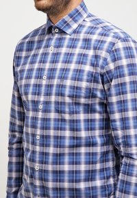 Blaue und weiße Karoshemel mit Button-down-Kragen, ausgestattet mit einer Brusttasche und blauen Knöpfen, aus einem Baumwollgemisch gefertigt.