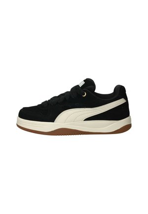 Sneaker nera basse con striscia bianca sui lati, lacci neri, colletto imbottito e suola in gomma marrone.
