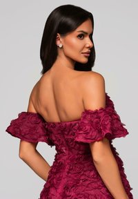 Off-shoulder bordeaux jurk versierd met gelaagde stoffen rozen. Soepele textuur, aansluitend lijfje met uitlopende mouwen, met een rugloze ontwerp.
