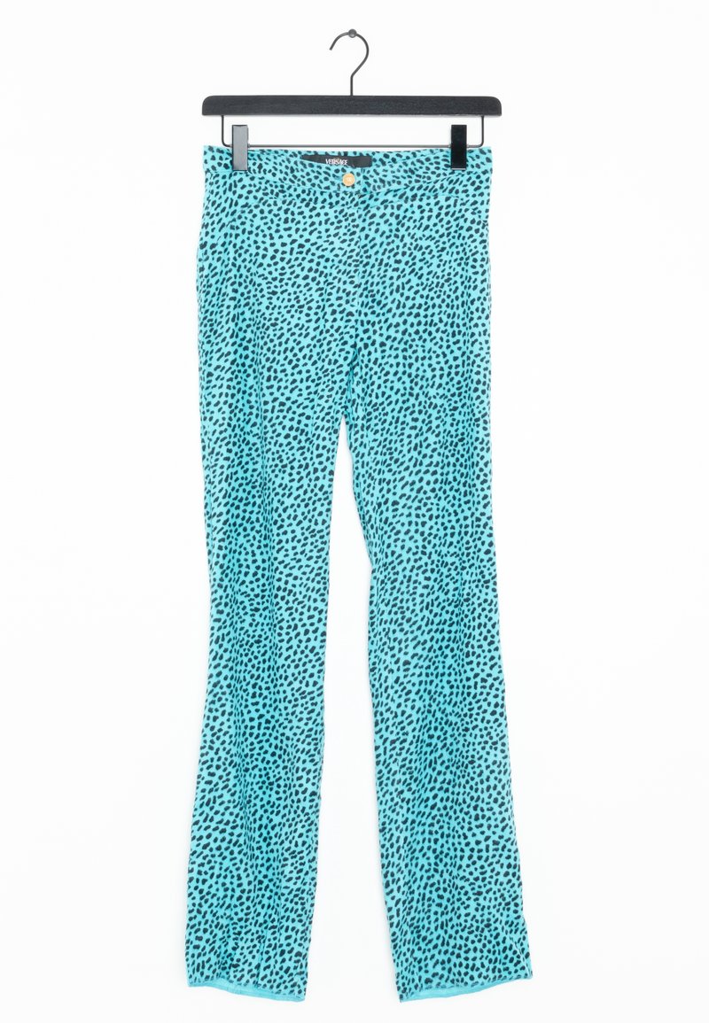 Turquoise rechte pijpen broek met een zwart onregelmatig stippenpatroon, gouden knoop en VERSACE label, hangend aan een zwarte hanger.