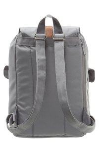 Sac à dos en tissu gris avec dos rembourré et bretelles ajustables. Présente un accent en cuir beige près du haut et une poche latérale zippée.