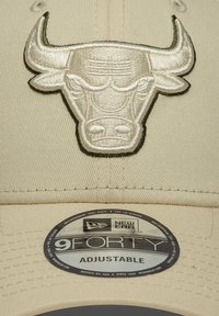 Μπεζ καπέλο μπέιζμπολ με κεντητό λογότυπο ταύρου σε κρεμ απόχρωση. Το καπέλο διαθέτει επίπεδη γείσο και ρυθμιζόμενο λουρί με την ετικέτα "9FORTY".