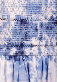 Tessuto blu e bianco arricciato con motivo tie-dye; presenta smock strutturato e dettagli plissettati all'orlo.