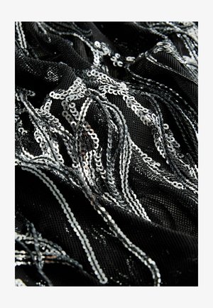 Czarna tkanina ozdobiona srebrnymi cekinami, tworząc teksturowany, błyszczący wzór. Cekiny tworzą falujące, faliste kształty na materiale.
