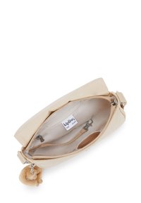 Borsa a tracolla in tessuto beige con una superficie liscia, chiusura superiore a zip e un accento in pompon peloso. Dotata di tasche interne e etichetta del marchio.