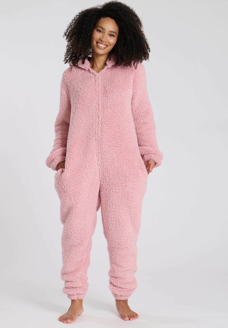 Rosa fleeceonepiece med huva, med en texturerad, plyschmaterial, långa ärmar och sidofickor. Slät dragkedjeöppning fram.
