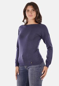 Maglione a maglia blu navy con maniche lunghe, scollatura rotonda e silhouette aderente. Presenta un piccolo logo vicino all'orlo.