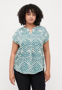 Short-sleeve top with a notched collar, featuring a teal and cream geometric pattern, made of a lightweight fabric, curved hem and relaxed fit.