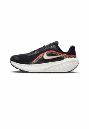 Schwarz-weißer Laufschuh mit gepolsterter Sohle, Leopardenmuster und roten Akzenten sowie einem goldenen Nike-Swoosh an der Seite.