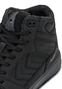 Baskets montantes noires avec une tige texturée, un col rembourré et des lacets. Présente un logo Hummex™ et un motif en chevrons subtil sur le côté.