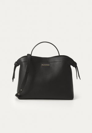 Black leather handbag with a textured finish, top handle, detachable shoulder strap, and gold logo accent. Features side ties and minimal hardware.
