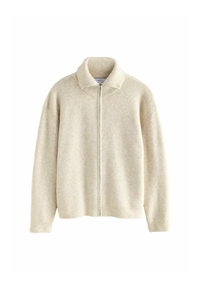 Cremefarvet strikket cardigan med ribbet struktur, høj krave og lynlås foran. Har dropped shoulders og lange ærmer, uden mønstre.
