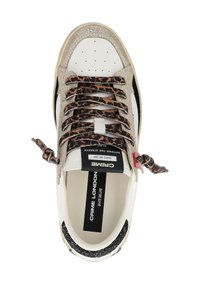 Sneaker bianco in pelle con accenti beige testurizzati, striscia nera laterale, lacci con stampa animale e etichetta del marchio sulla linguetta.