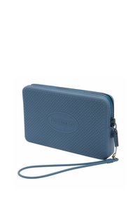 Portafoglio blu con zip realizzato in gomma testurizzata, dotato di una cinghia discreta e di un logo impresso, con chiusura a zip liscia.