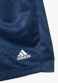 Mörkblå träningsshorts med ett strukturerat mönster, prydda med en vit Adidas-logotyp på den nedre vänstra fållen. Mjukt, lätt tyg.
