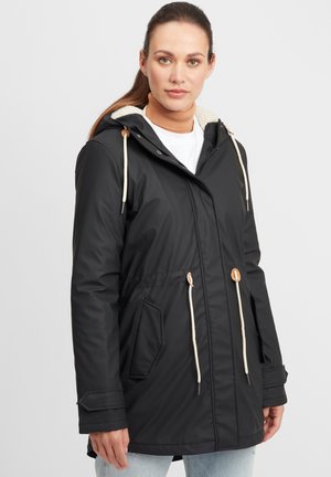 Zwarte waterdichte jas met een capuchon, beige voering, toggles en voorzakken. Kenmerkt een aangesnoerde taille en gestructureerde stof.