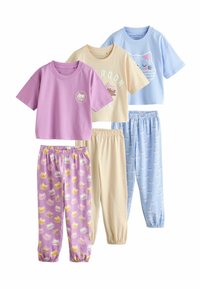 Quatre ensembles de vêtements de nuit pour enfants : un T-shirt violet avec un motif mignon, un T-shirt beige, et un pantalon de pyjama à motifs avec des gâteaux et des chatons.