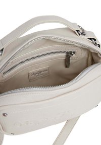 Bolso de cuero blanco con un compartimento principal con cremallera y un bolsillo interior. Presenta una textura suave y un logotipo en relieve sutil.