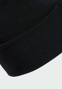Berretto in maglia nera con texture a coste, caratterizzato da un risvolto. Realizzato in tessuto morbido ed elastico. Forma arrotondata senza marchi visibili.
