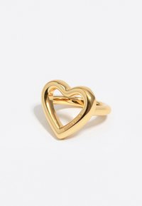 Kultaketju, jossa on avoimen sydämen muotoilu, sileä kiillotettu pinta ja kaiverrus "BIMBA Y LOLA" sydämen muodon sisäreunassa.