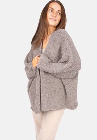 Grauer, flauschiger Cardigan mit offenem Front, weiten Ärmeln und lockerer Passform. Weiche Textur mit einem gemütlichen, entspannten Design.