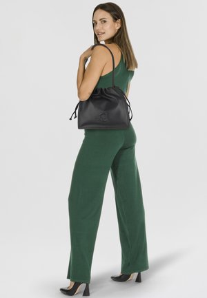 Black leather bucket bag with drawstring closure, featuring embossed logo. Smooth texture and soft, structured silhouette.