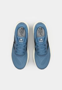 Modré sportovní boty s textilií ze síťoviny, černými akcenty a bílou podrážkou. Obsahují tkaničky, logo "Fresh Foam" a perforovaný design pro prodyšnost.