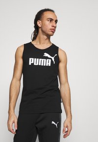 Camiseta preta sem mangas em algodão com um grande logótipo branco "PUMA" e um gráfico de uma puma a saltar. Detalhe de tecido texturizado na gola.