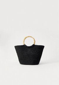 Black woven straw tote bag with a textured surface, open top, and a circular bamboo handle. Features a wide base tapering towards the top.
