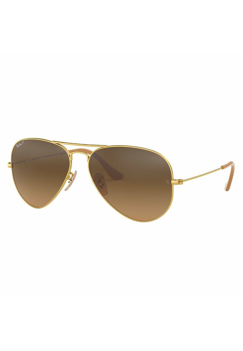 Occhiali da sole stile aviator con montatura in metallo dorato, lenti sfumate marroni e terminali delle aste in plastica. Presentano un design a doppio ponte e accenti minimali.