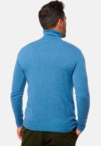 Blauer Rollkragenpullover mit weichem Griff, gerippten Bündchen und Saum. Das Design ist tailliert, hat lange Ärmel und eine glatte Oberfläche.