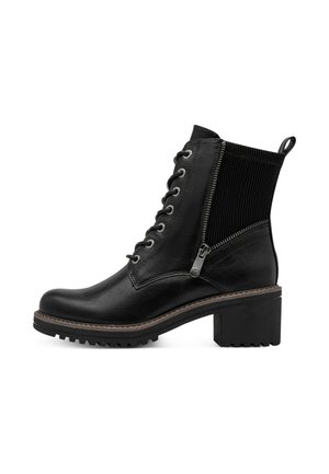 Bottine en cuir noir avec lacets sur le devant, fermeture éclair latérale, tige en tissu côtelé, talon épais et languette à l’arrière.