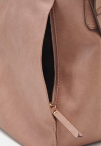 Borsa in pelle rosa con cerniera visibile e fodera scura. Presenta una texture liscia e dettagli in oro. Il tiralampo della cerniera è fissato.