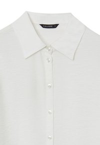 Weißes Hemd mit Kragen, aus strukturiertem Stoff mit fünf Knopfverschluss. Verfügt über einen subtilen Glanz und das Etikett "CALLIOPE" auf der Innenseite des Kragens.