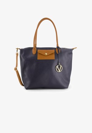 Marineblauwe leren tote bag met tan accenten, voorzien van een voorzak, gouden hardware, bovenste ritsafsluiting en een afneembare schouderriem.