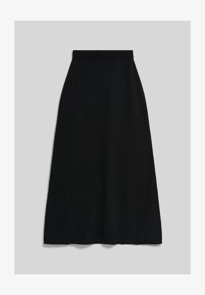 Jupe noire en ligne A avec une taille cintrée, tombant à mi-mollet sur un fond gris clair uni.