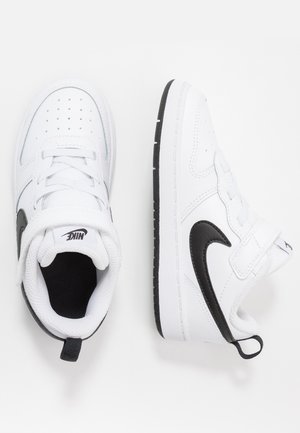 Scarpe da ginnastica Nike per bambini piccoli bianche e nere con cinturini in Velcro, loghi swoosh neri e colli imbottiti su sfondo bianco.