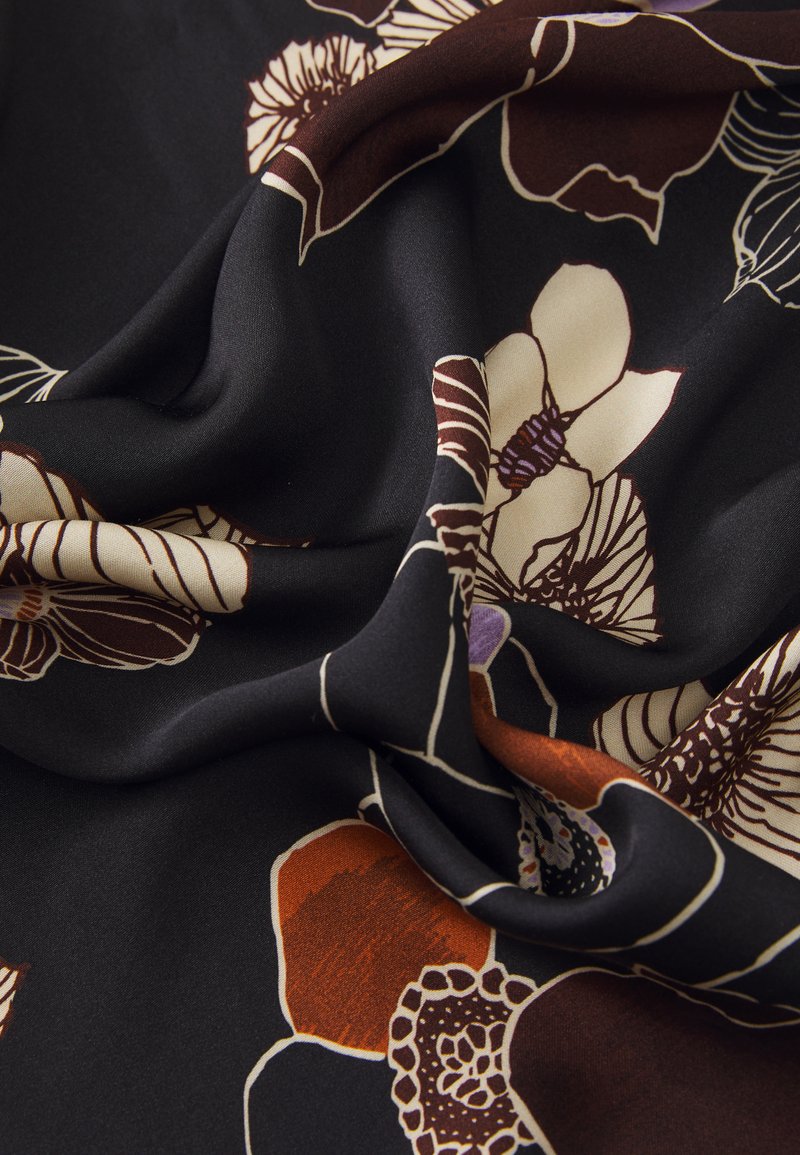 Black fabric featuring large floral patterns in cream, brown, and hints of purple. The texture is soft and flowing, with vibrant color contrasts.