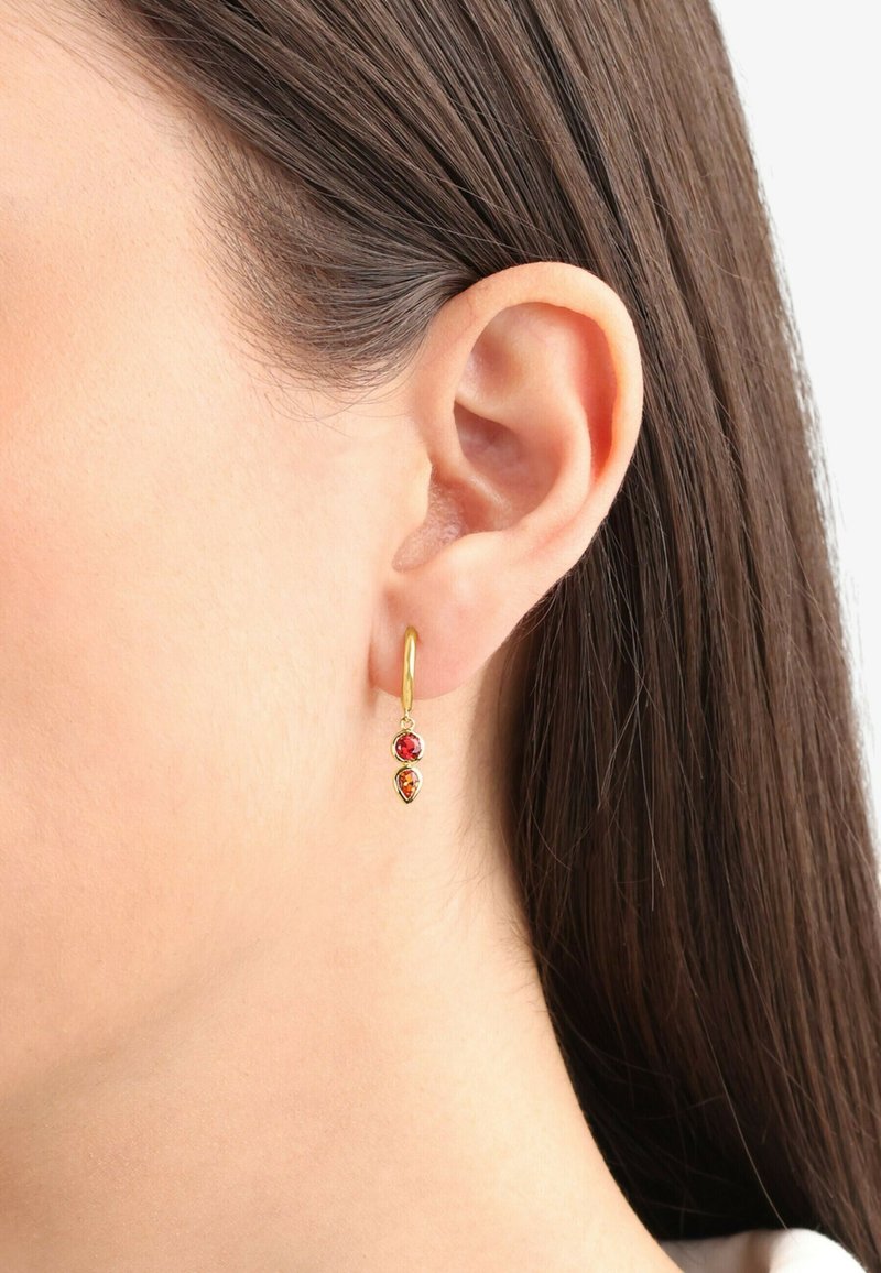 Orecchino a cerchio in oro con due pietre pendenti: una rossa e una ambra. Progettato con forme a goccia, presenta una finitura lucida e una chiusura aperta.