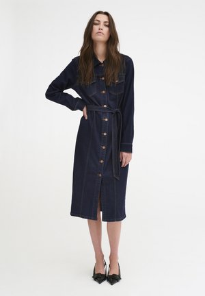 Jeansklänning med långa ärmar, mörkblå färg, knäppning framtill, två bröstfickor, midjeband och slits fram till knäna.