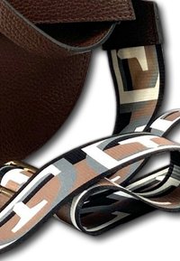Brown leather handbag with a patterned strap featuring black, white, and brown geometric designs, showcasing a smooth texture and gold hardware.