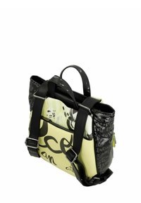 Bolso tote colorido con base amarilla, texto en negro, correas texturizadas negras y detalles con patrones en negro y gris.