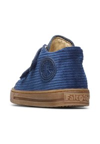 Scarpa di velluto a coste color navy con suola in gomma beige, caratterizzata da una toppa circolare con logo sul lato e parte superiore testurizzata per un maggiore interesse visivo.