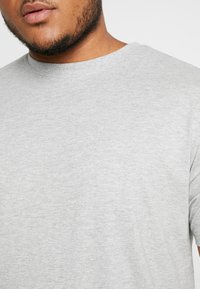 Light gray short-sleeve t-shirt made of a soft cotton blend, featuring a round neckline and a smooth, fine texture.