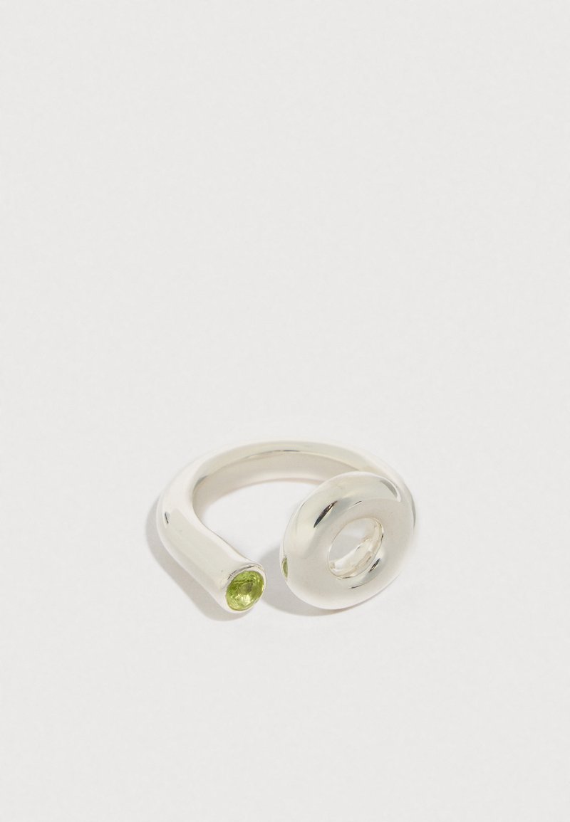 Bague en argent à la forme torsadée et fluide ; ornée d'une pierre précieuse verte et d'une ouverture circulaire. Finition lisse et polie.