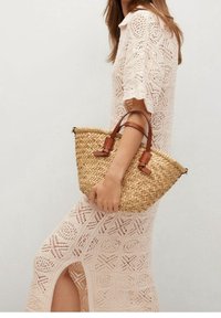 Sac à main en paille tissée avec des poignées en cuir marron ; de taille moyenne, avec une forme structurée, texture naturelle et couleur brun clair.