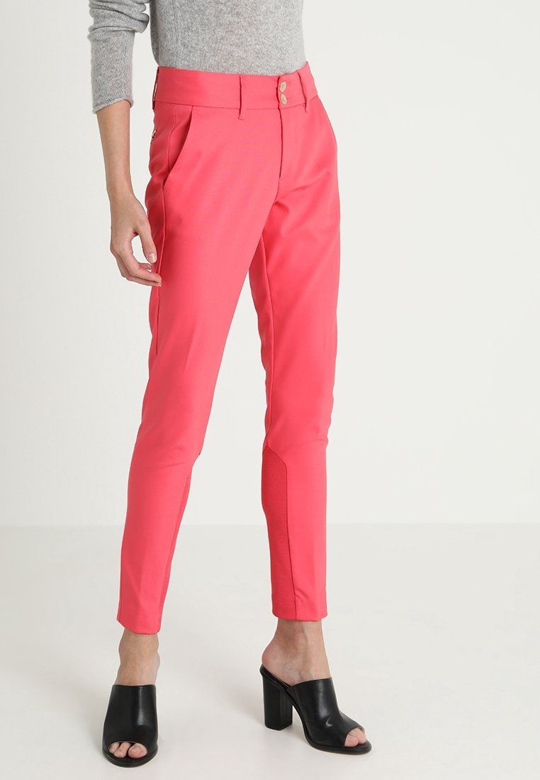 Vaaleanpunaiset joustavat housut, joissa on sileä pinta, korkea vyötärö, kaksoispainonappi ja sivutaskut. Yhdistetty mustiin korkokenkiin.