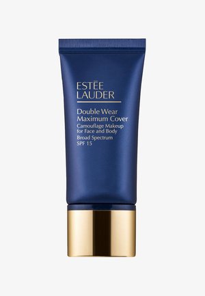 Tubo azul con borde dorado etiquetado "Double Wear Maximum Cover", que presenta un SPF 15 de amplio espectro para rostro y cuerpo, con un acabado mate suave.